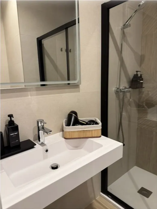 Baño moderno con lavabo y ducha relucientes