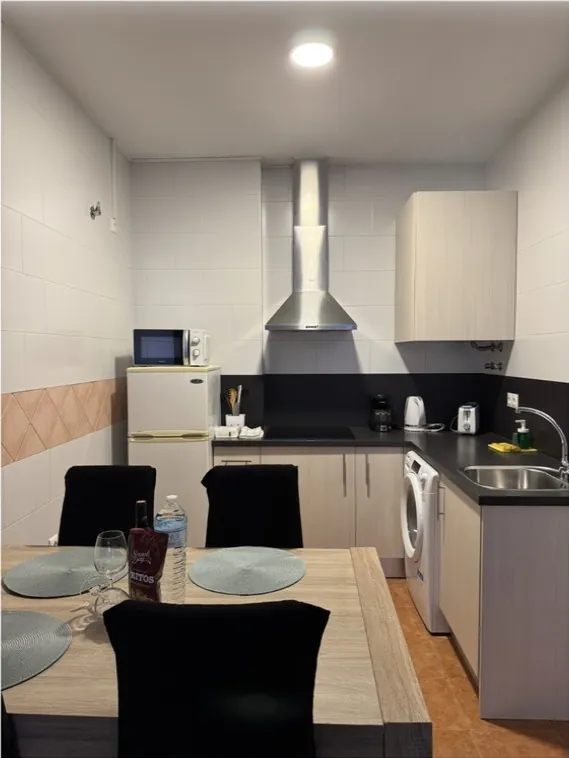 Cocina con campana y encimera negra limpias