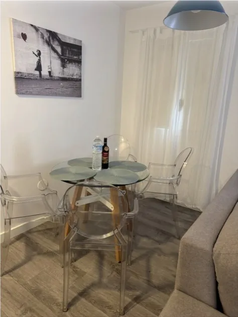 Comedor con mesa de cristal y sillas transparentes