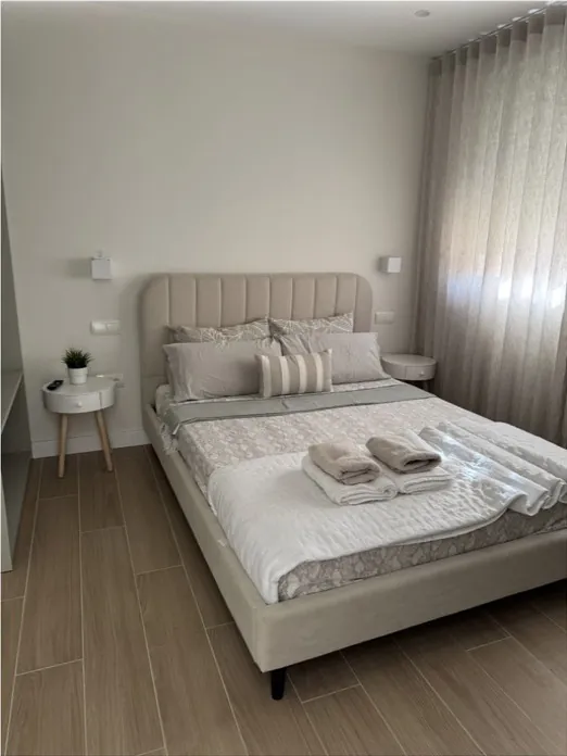 Dormitorio con cabecero tapizado y cama preparada